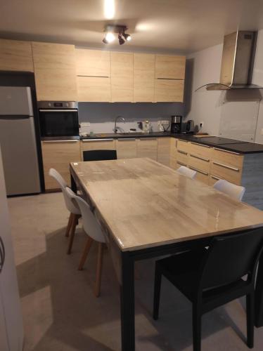 a kitchen with a wooden table and chairs at Maison 3 chambres avec jardin Gien in Gien