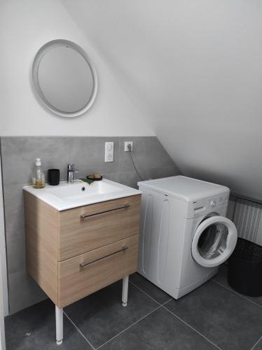 a bathroom with a washing machine and a sink at Maison 3 chambres avec jardin Gien in Gien