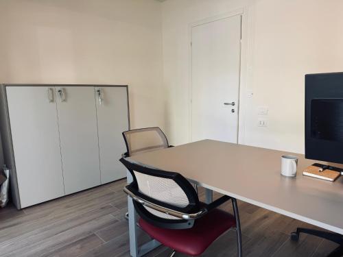 an office with a desk and a chair and a tv at Residenza esclusiva appena costruita in Imola