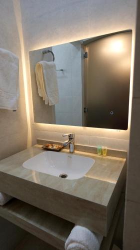 a bathroom with a sink and a mirror at Royal Suites Muscat in Ma‘ābīlah
