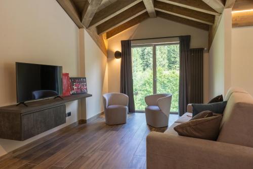 a living room with a couch and a tv at Lillaz Home - Apartments in Cogne