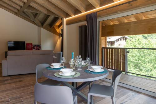 a dining room with a table and chairs and a large window at Lillaz Home - Apartments in Cogne