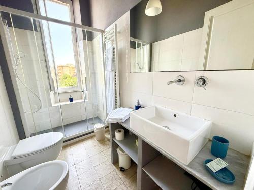 a white bathroom with a sink and a toilet at Free Parking 5 minutes from the station in La Spezia