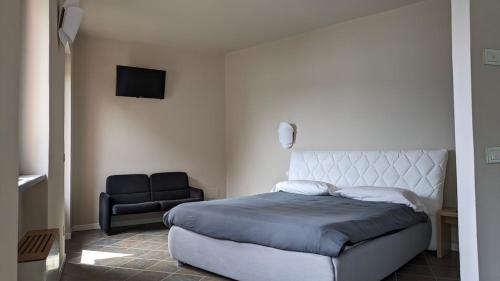 a bedroom with a large bed and a chair at Appartamento La Selva in Orta San Giulio