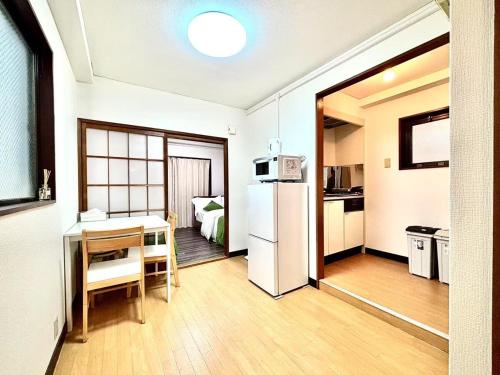 a kitchen with a table and a white refrigerator at 3F 3 minutes walk from Nishi-Oi Station, Shinagawa Ward, 4 stations available, surrounded by commercial streets, rich life, convenient transportation in Tokyo