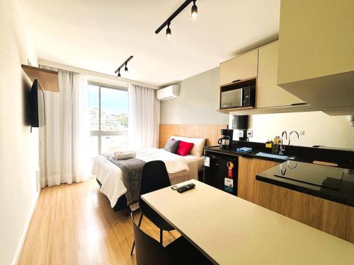 a hotel room with a bed and a kitchen at UniHome Niterói in Niterói