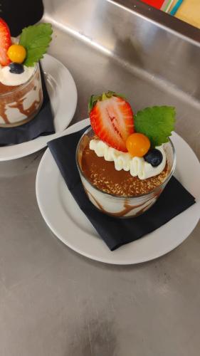 a bowl of dessert with fruit on a plate at Sveggvika Guesthouse in Averoy