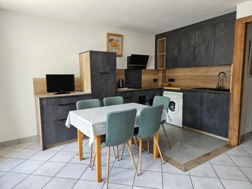 une cuisine avec une table et des chaises dans une pièce dans l'établissement Charmant 2 pièces, 5 pers, 3 étoiles, balcon sud, centre Valloire à 50m des pistes - FR-1-263-84, à Valloire