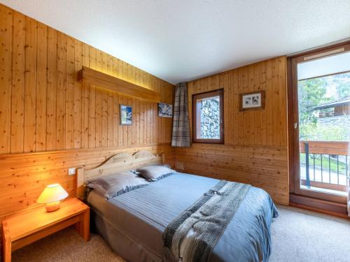 une chambre avec un lit dans un mur en bois dans l'établissement Appartement 2 pièces avec parking, proche des pistes et du centre à Val-d'Isère - FR-1-694-284, à Val dʼIsère