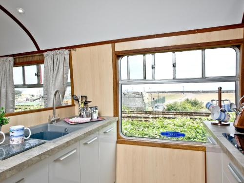 a kitchen with a sink and a window at Brunel Boutique Railway Carriage 4 in Dawlish Warren