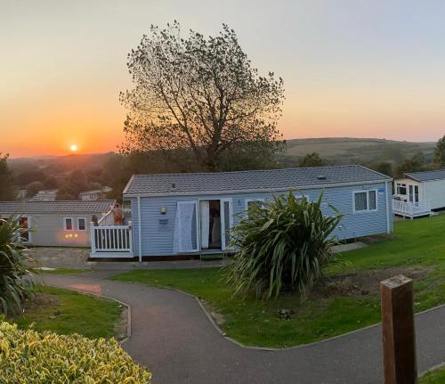 a house with the sun setting in the background at Beautiful beach themed static caravan in Hastings