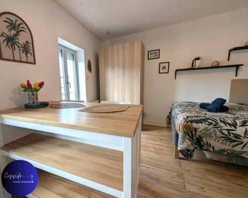 Zimmer mit einem Schreibtisch, einem Bett, einem Bett und einem Tisch in der Unterkunft L'Oasis by Cozylife - Centre Ville in Niort