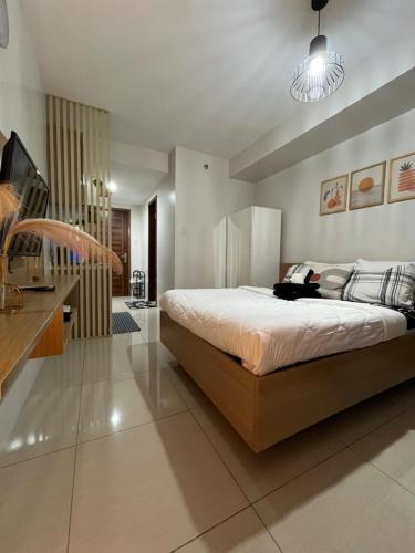une chambre avec un grand lit et une télévision dans l'établissement Horizon 101, à Cebu