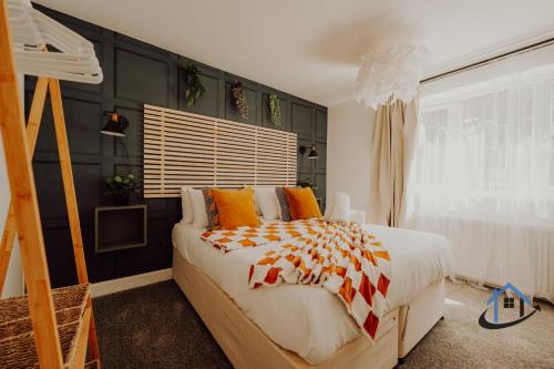 a bedroom with a large bed with orange pillows at FLAT 5 - Ground floor 2 bed apartment free parking sleeps 6 in Halesowen