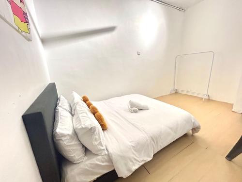 a room with a bed with white sheets and pillows at Cozy10perwira#6pax#Netflix#neariconcity&iconicpoint in Simpang Ampat