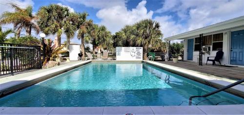 a swimming pool with blue water in front of a house at Coral Sands 1br/1ba Close 2 Beach! in West Palm Beach