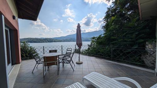 a patio with a table and chairs and an umbrella at Appartamento 5 Terre in Orta San Giulio