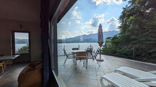 a balcony with a table and chairs and a view of the water at Appartamento 5 Terre in Orta San Giulio