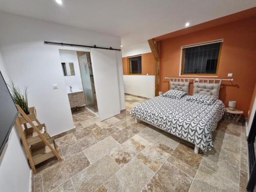 a bedroom with a bed and a tiled floor at Chez Nathan et Anaïs, Clim, piscine, pétanque, rivière in Vallon-Pont-dʼArc