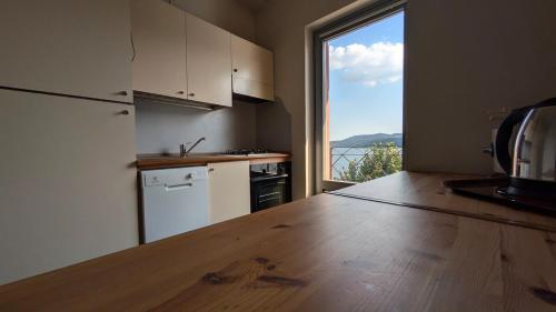 a kitchen with a counter top and a large window at Appartamento 5 Terre in Orta San Giulio