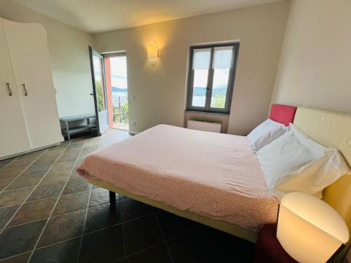 a bedroom with a large bed and two windows at Appartamento 5 Terre in Orta San Giulio