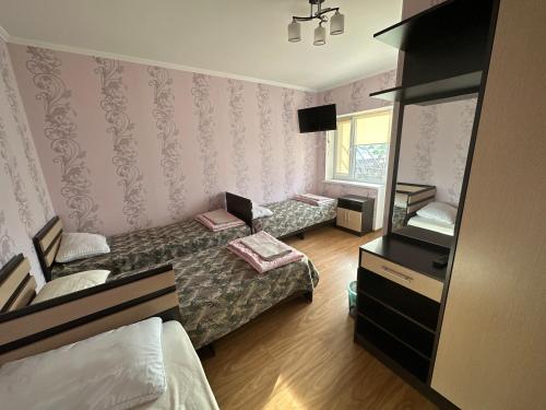 a small room with two beds and a window at Jany Tilek in Bosteri