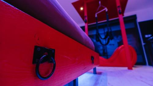 a close up of a red bench in a playground at Loveroom Very Good Trip chambre avec jacuzzi privatif in Staple