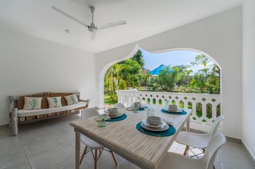 a dining room with a table and chairs at Hibiscus in Diani Beach