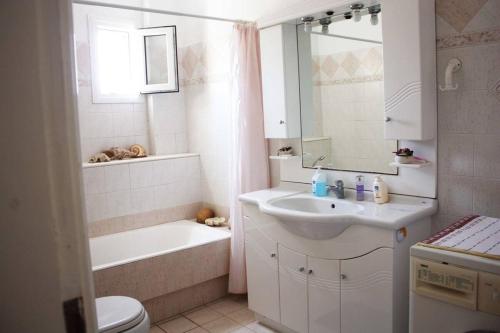 a bathroom with a sink and a tub and a toilet at Villa Skamnia in Kinídharos