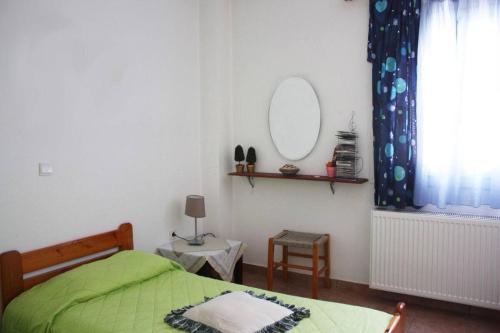 a bedroom with a green bed and a mirror at Villa Skamnia in Kinídharos