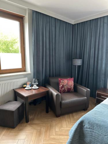 a hotel room with a bed and a chair and a table at Świat Jezior in Mikołajki