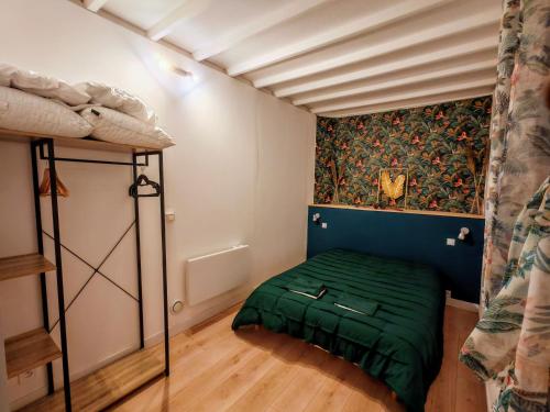 ein Schlafzimmer mit einem grünen Bett in einem Zimmer in der Unterkunft Gîte Nature sur LAC avec accès PISCINE et PONTON in Éguzon-Chantôme
