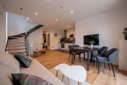 a living room with a couch and a table and chairs at Appartement an der alten Linde in Weil