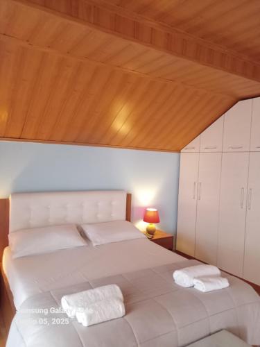 a bedroom with a large bed with a wooden ceiling at Villa Mondi in Durrës
