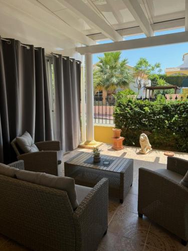 a living room with chairs and a table and curtains at Villa Casa del Sol in Mazarrón