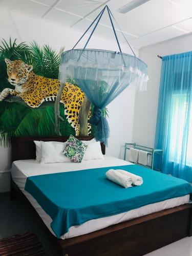 a bedroom with a bed with a painting of a leopard at Casa Del Ceylon in Hikkaduwa