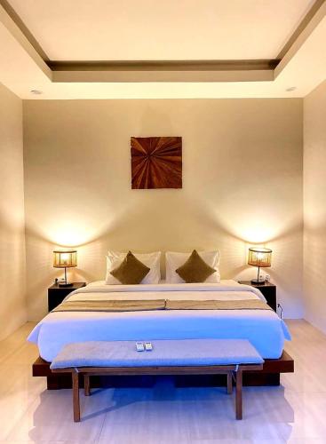 a bedroom with a large bed with two lamps at KU Villas in Kuta Lombok