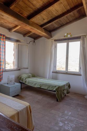 a bedroom with two beds and two windows at Buen Retiro in Portoferraio