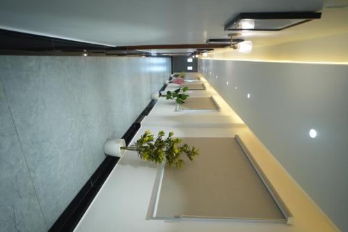 a row of tables with plants on them in a room at Hotel Avasa in Tenāli