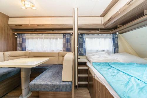 a small room with a bed and a table at Urlaub im Wohnwagen mitten im Wald in Lütow