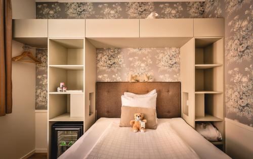 a teddy bear sitting on a bed in a bedroom at Freys Hotel in Stockholm