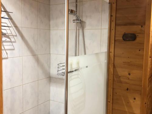 une douche avec une porte vitrée dans une salle de bain dans l'établissement Appartement moderne 3 chambres avec balcon, près des pistes, parking et garage - FR-1-467-53, au Grand-Bornand