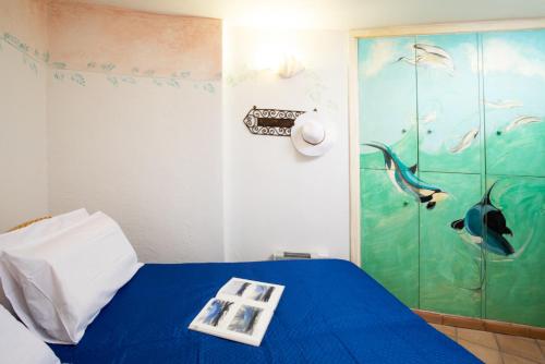 a bedroom with a blue bed with a dolphin painting on the wall at Casa Irene by Wonderful Italy in Porto Cervo