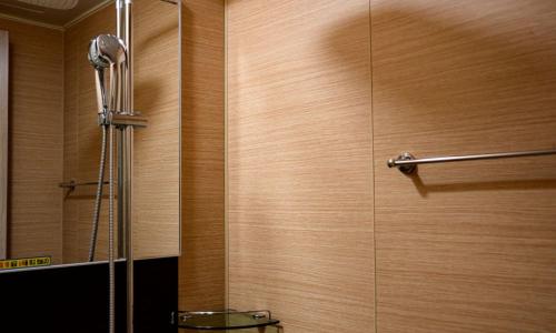 a shower in a bathroom with a wooden wall at Jeonju Wangyijimil Hanok Hotel in Jeonju