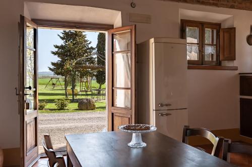a kitchen with a table and a door to a yard at Podere Conte Ugo in Contignano