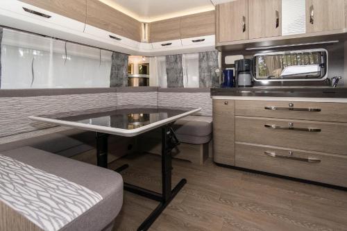 an rv kitchen with a table and a sink at Urlaub im Wohnwagen mitten im Wald in Lütow