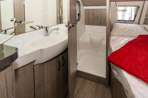 a bathroom with a sink and a mirror at Urlaub im Wohnwagen mitten im Wald in Lütow