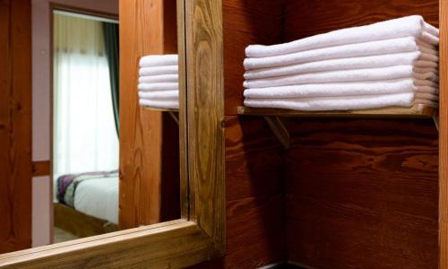 a stack of towels on a shelf next to a mirror at Jeonju Wangyijimil Hanok Hotel in Jeonju