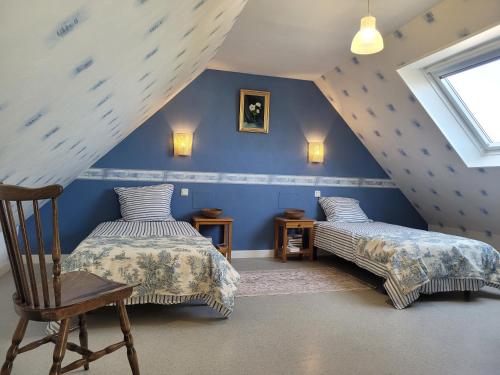 a attic room with two beds and a chair at Maison Ty Pempoul rénovée, Confort, accessibilité et sérénité à Paimpol in Paimpol