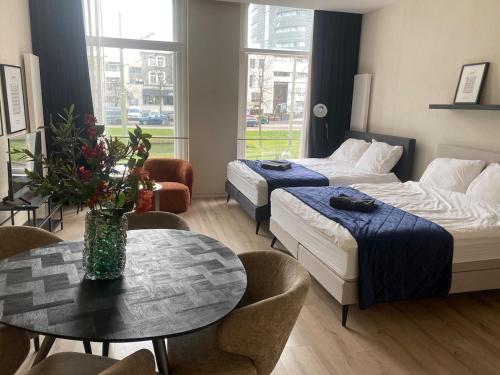 a hotel room with two beds and a table at Luxurious central apartment in Rotterdam